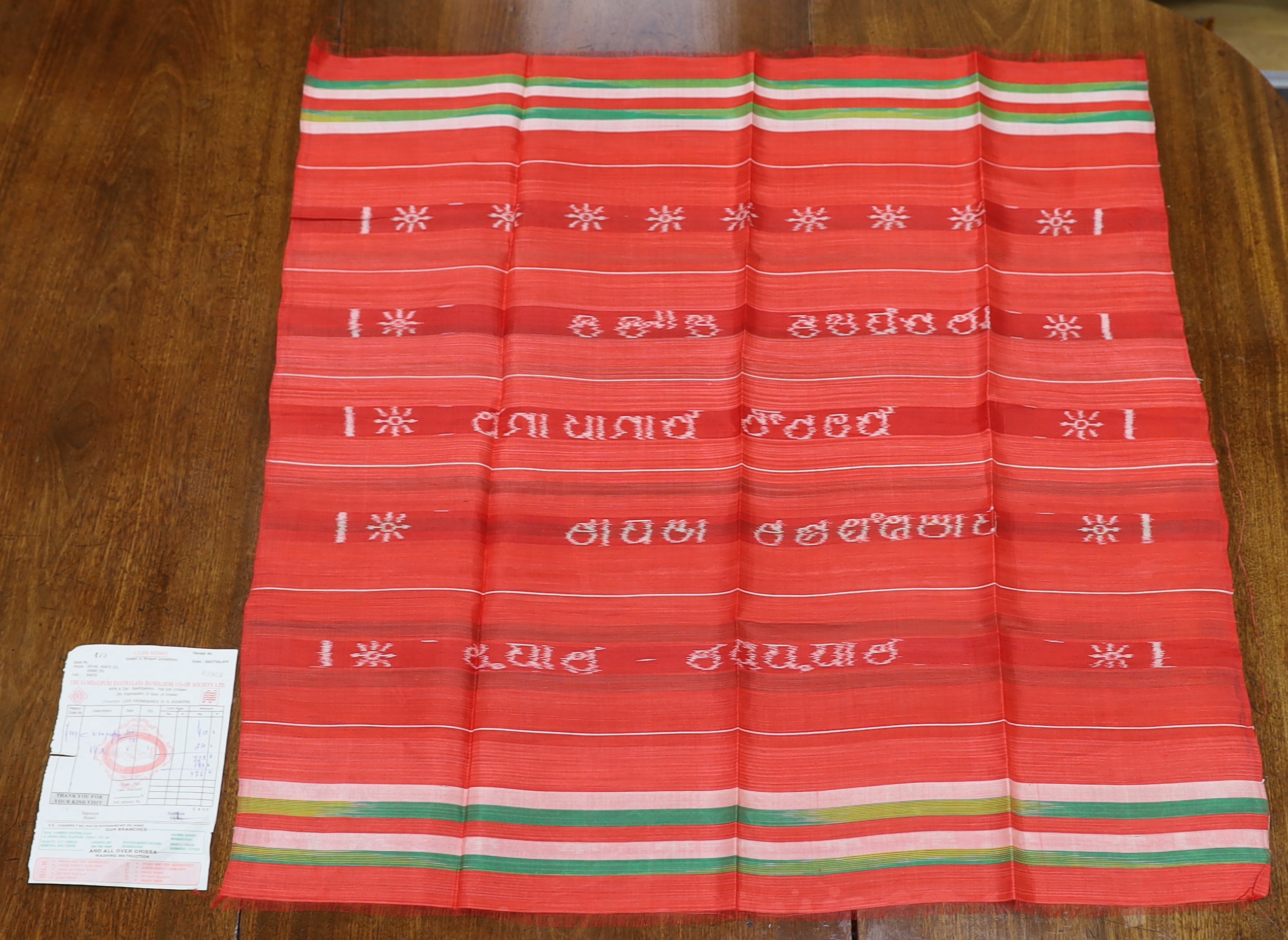 An Indian silk woven cloth, possibly a temple cloth, from Orissa, printed on the warp, with original receipt and paper bag